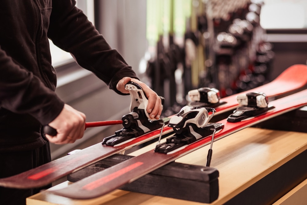 A view of a person repairing a ski