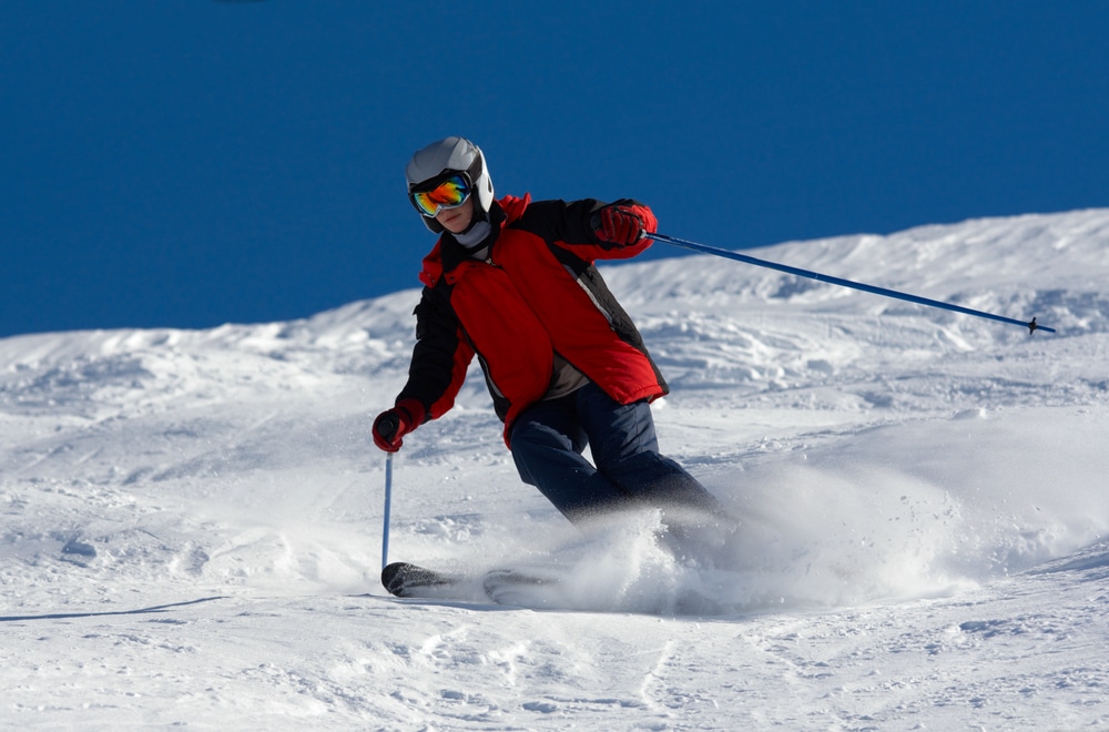 A view of a skier wearing helmet skiing in snow