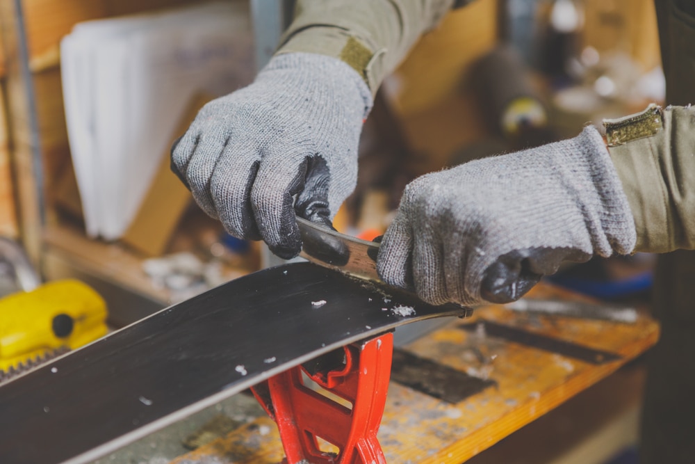 A view of the hands of worker repairing a ski