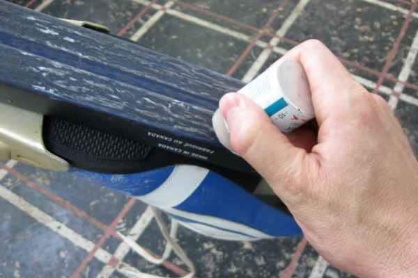 a man doing ski waxing with his hand