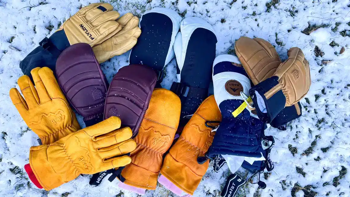 a variety of ski gloves and mittens lying on snow