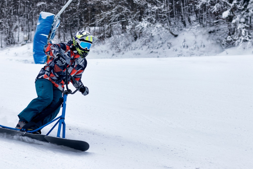 Riding Downhill On A Snowscoot