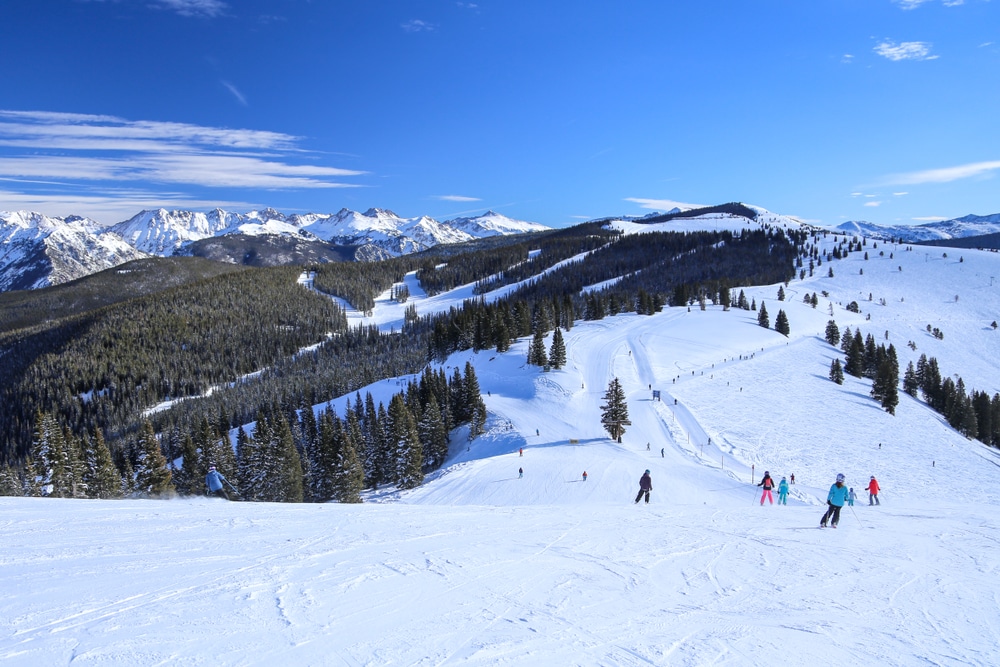 People Skiing Toward The Back Bowls And Blue Sky Basin