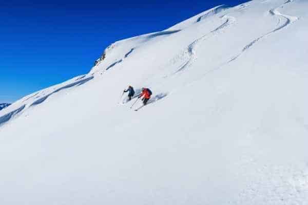 two skiers doing bowl skiing