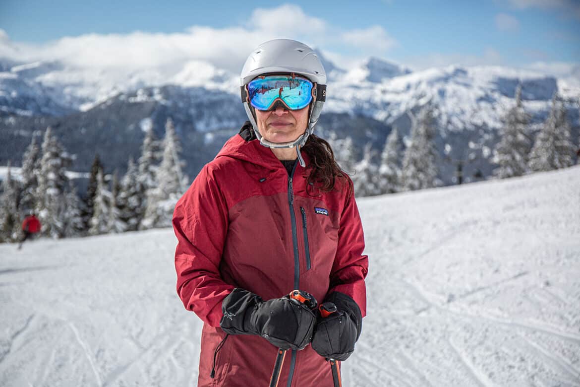 A view of a lady wearing a skiing red jacket in snow A view of a lady wearing a skiing red jacket in snow
