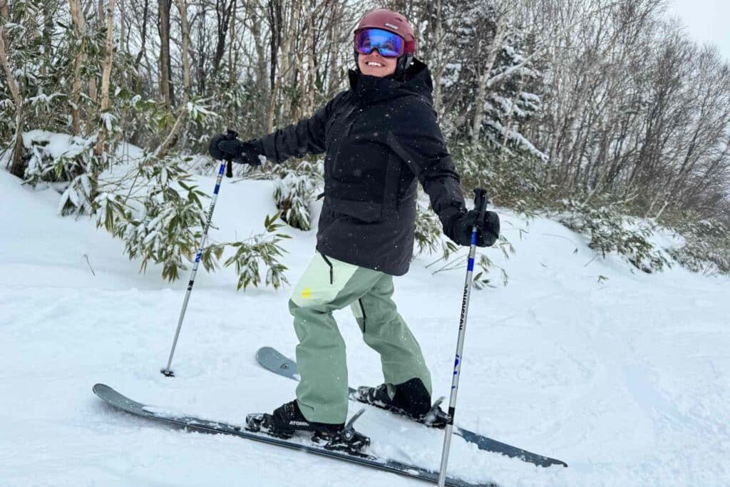 A skier enjoys the snow smiling while skiing on a snowy trail A skier enjoys the snow smiling while skiing on a snowy trail